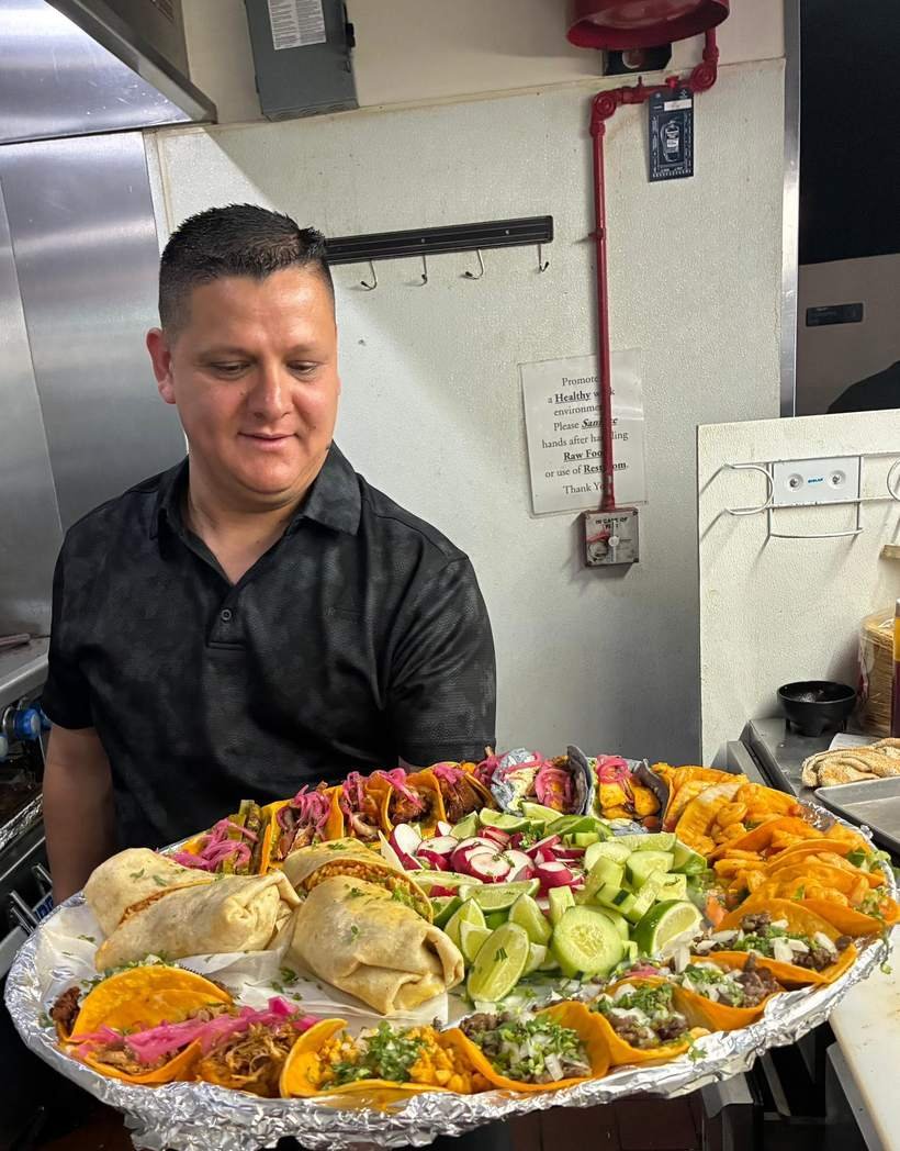 Ronaldo Ramirez Lopez with a full platter of tacos in the kitchen