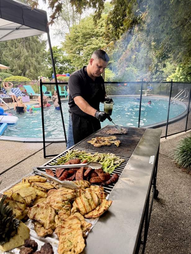 Ronaldo grilling chicken, chorizo and pineapple at a poolside party