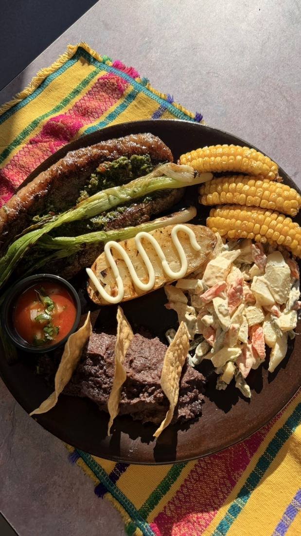 Puyaso, refried beans, corn on the cob, baked potato and salad.